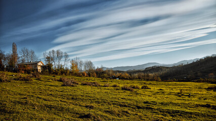 Special clouds on a spring day, view of mountains, trees and meadows