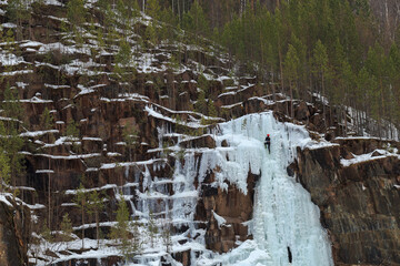 athletes - climbers train on a glacier, young climbers climb an icy rock with a safety rope