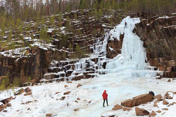 athletes - climbers train on a glacier, young climbers climb an icy rock with a safety rope