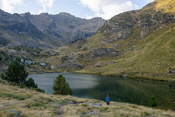Fototapeta na wymiar young caucasian girl climbing the path that leads to lake tristaina in andorra among the mountains