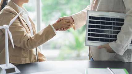 Alternative energy environment businesspeople shake hands after deal about solar cell panel project