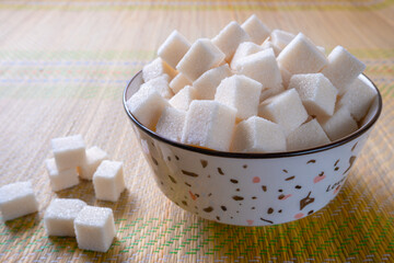 Sugar cubes in a bowl on the table. Selective focus.