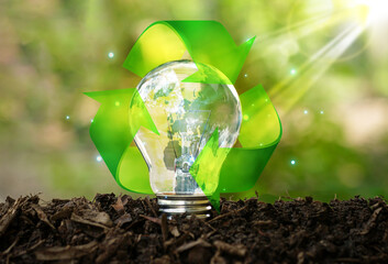 Light bulb with earth globe, recycle symbol on soil ground and sunshine in green garden background.Solar energy sources idea for renewable.Concept saving power energy in nature.World environment day.