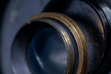 Brass elements of an old lens close-up. Shiny metal surface.