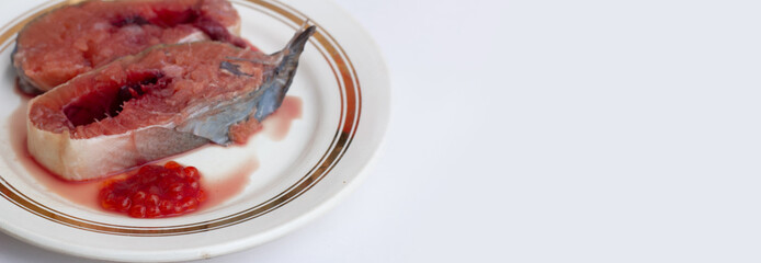 Horizontal banner. Raw fresh red fish on plate with golden border on white background with space for cooking recipe text. Salmon steak for frying with caviar. Healthy food, cuisine, seafood concept