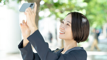 スマホで写真を撮る女性