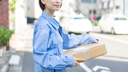 荷物を運ぶ女性配達員