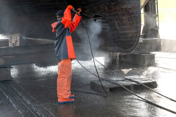cleaning a ship in the dry dock, cleaning the hull with a high-pressure blaster