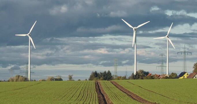 Windkraftanlagen und Bauernhof im Hintergrund.