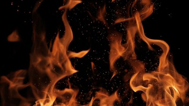 Flames and sparks of fire on a black background. A big bonfire. Fire and danger. Burning wood in the fireplace. Romantic fire. Fire at night.