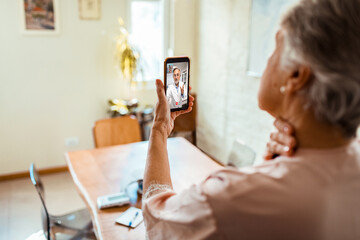 Elderly woman consulting with her doctor via a virtual telehealth session