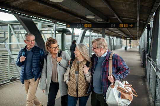 Elderly friends sharing a jovial moment at a train station