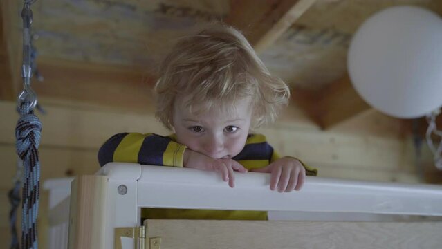 Cute Blond Boy Standing Inside Crib At Home - Fairbanks, Alaska