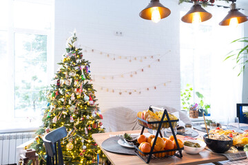 Serving a festive table with snacks, salads and goodies close-up in the modern interior of a loft house decorated for Christmas and New Year. Waiting for guests for a festive dinner