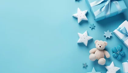 Poster Baby accessories concept top view photo of gift box teether knitted bunny rattle toy and stars on isolated pastel blue background with empty space © Bold24
