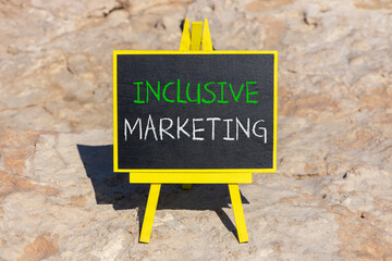 Inclusive marketing symbol. Concept words Inclusive marketing on beautiful black blackboard. Beautiful stone beach background. Business inclusive marketing concept. Copy space.