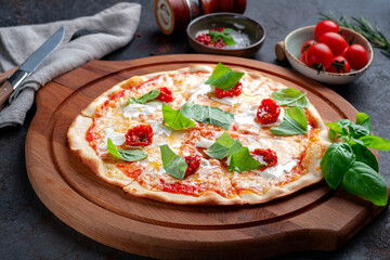 Pizza with strachatella, dried tomatoes and fresh basil. Italian pizza with Stracciatella cheese