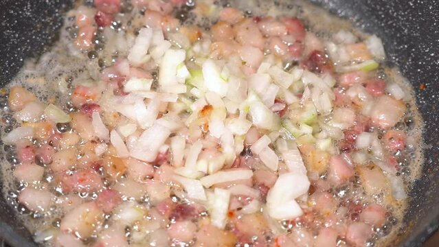 roasting of salted pork fatback with onion on a red-hot pan, close-up	

