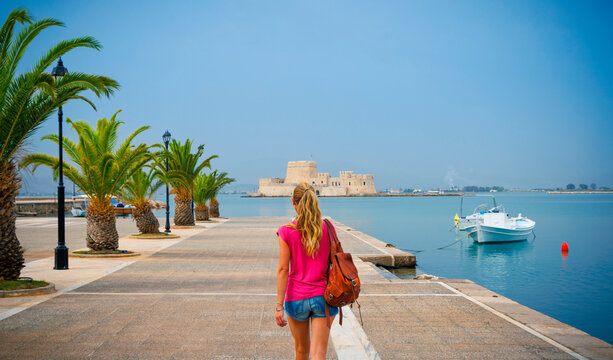 Nafplio town in Greece, Argolis bay,  Bourtzi castle and fishing boat at sunset