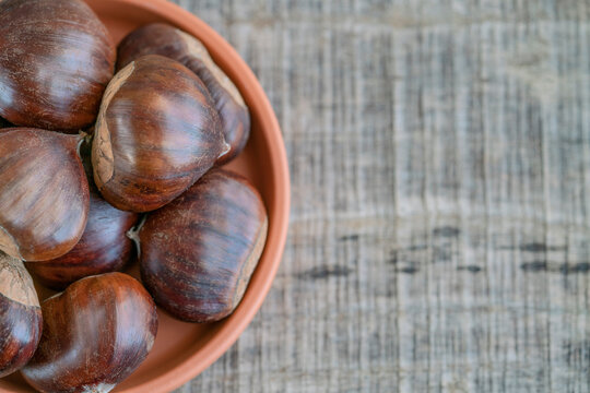 raw ripe chestnuts on wooden table