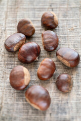 close up raw chestnuts on wooden table