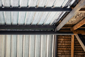 Ceiling covered with insulation combined with thatched roof. Aluminum foil installed under roof for...