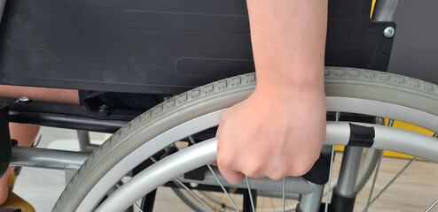 Closeup of child hand in wheelchair. Spinal injury in children