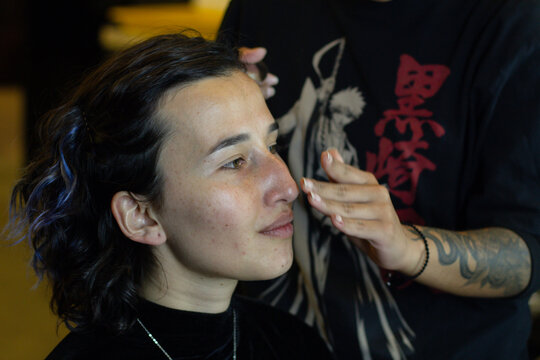 young woman being made up by a professional makeup artist in a dressing room