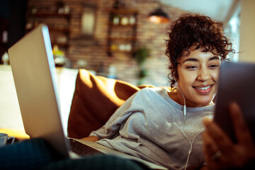 Joyful woman enjoying music while browsing on her laptop