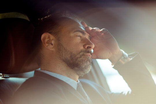 Businessman lost in deep thought during a car ride