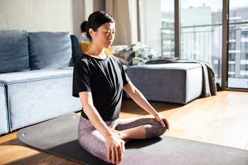 Japanese woman practicing meditation in a sunlit room