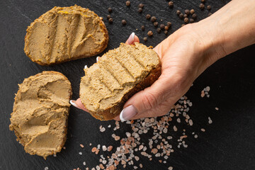 liver pate  spread on the bread fuagra chicken pate closeup space for text sand wich in the hand...
