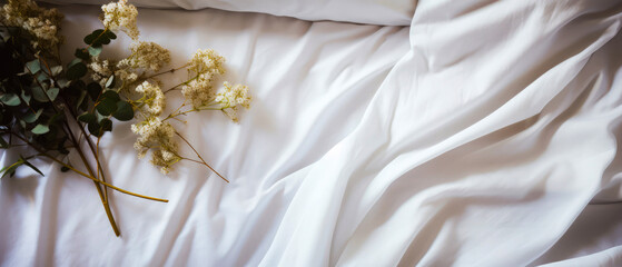 White silk bed sheet with  pillow, flowers, green leaf. Valentines  Day.Top view, flat lay. Satin fabric background. Female romantic mockup. Morning relax leisure. Hotels bedroom.Generative ai.