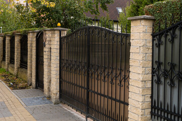 October 7, 2023 Russia, Zelenogradsk, cast forged gates reinforced with brick pillars