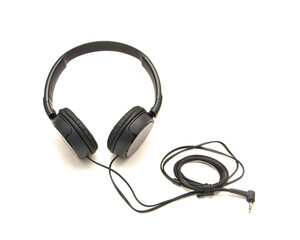 Side view black wired headphone with swiveling earcup foam cushions, L-shaped stereo mini plug 3.5mm isolated on white background, corded kids headphones dome type