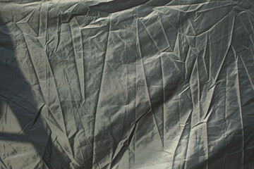 Crumpled fabric of black color. Surface of awning. Wrinkled texture.