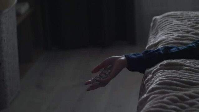 Overdose. Hand with pills falling down. Depressed woman falling dawn because of overdose