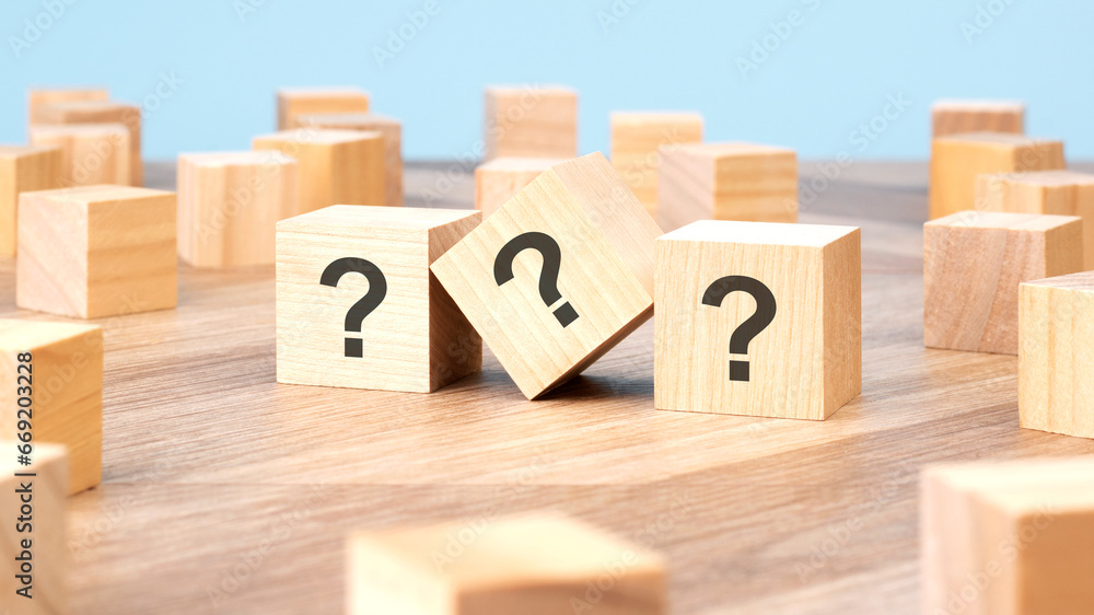 Poster three wooden cubes with question marks over a blue background with copy space
