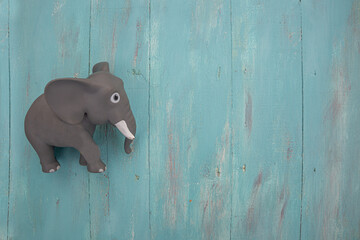 Little gray toy elephant on blue wooden vintage background with copyspace