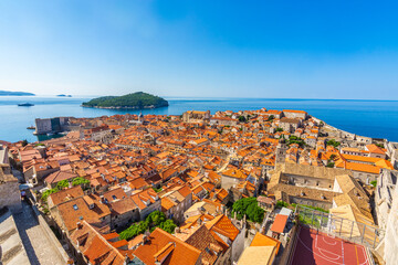 Naklejka na ściany i meble Aerial view of the red tiles and building roofs old city Dubrovnik in a beautiful summer day, Croatia. Blue sea with beautiful landscape, aerial view, Dubrovnik, Croatia