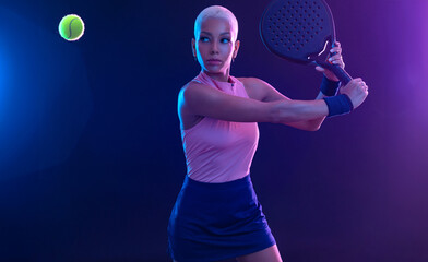 Padel tennis player with racket on tournament. Girl athlete with paddle racket on court with neon...