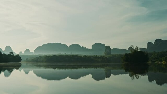 Quiet river with reflection of mountains and blue sky on the water. Static shot