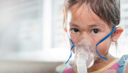 Kid girl making makes inhalation nebulizer steam sick cough at home, Asian Child using nebulizer...