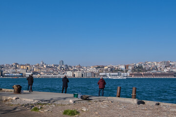 Fishermen catch fish on the pier in İBB Sarayburnu Parkı, Istanbul, Turkey