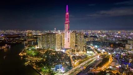 Fotobehang Aerial sunset view at Landmark 81 - it is a super tall skyscraper and Saigon bridge with development buildings along Saigon river, cityscape in the night © CravenA