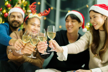 Group of diverse ethnicity young people enjoy celebrating a Christmas and New Year party together with a lot of foods and drinks. Friends celebrate Christmas and New Year festival and drink a wine.