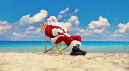 Santa claus on a beach chair and relaxing by the sea