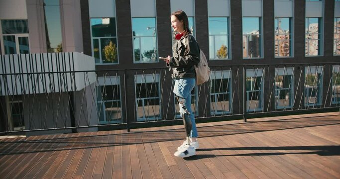 Young woman student with prosthetic leg walking in university campus. Woman with bionic leg. Woman with leg prosthesis equipment