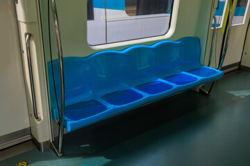 Subway train carriage, interior with blue seats and handrails