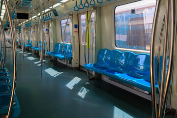 Subway train carriage, interior with blue seats and handrails